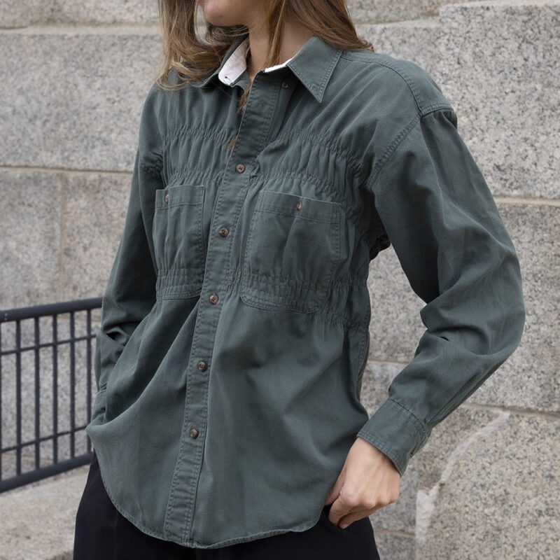 woman in green button-up and black trousers