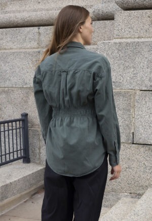 woman in green button-up and black trousers