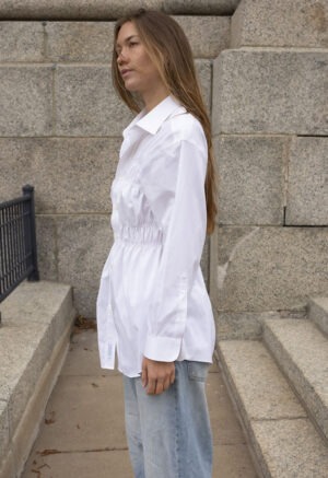 woman in white button-up and jeans