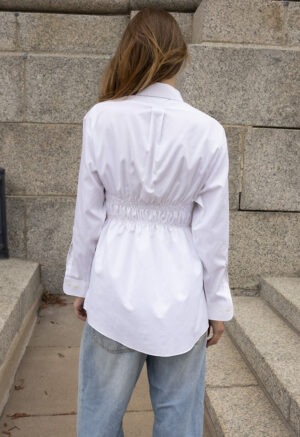 woman in white button-up and jeans