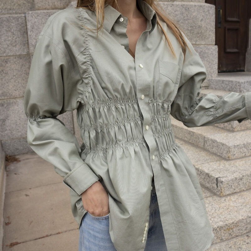woman in tan button-up and jeans