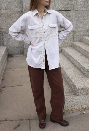 woman in cream button-up and brown pants