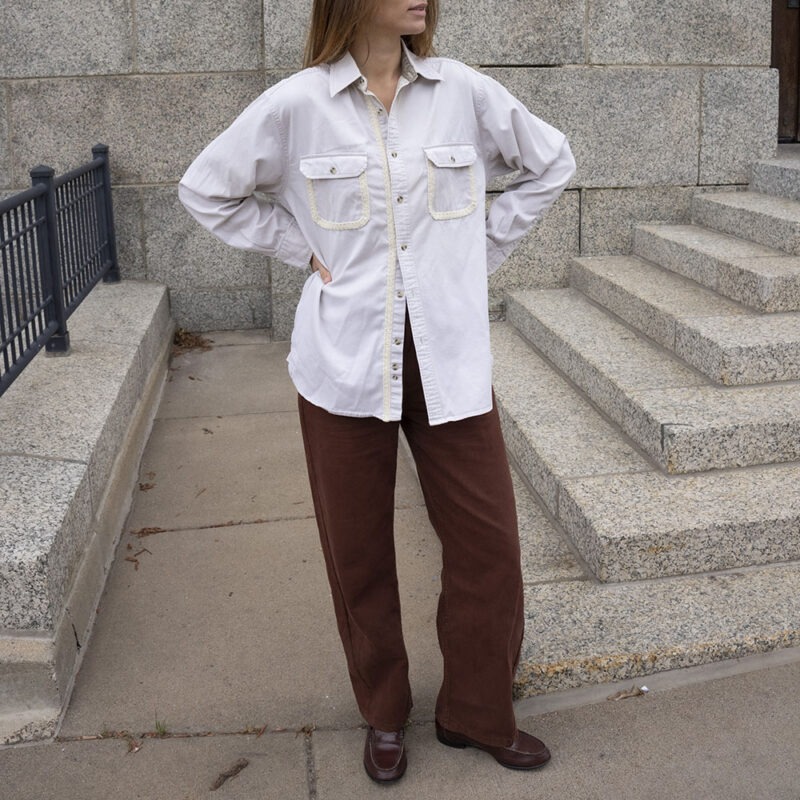 woman in cream button-up and brown pants