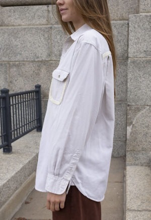 woman in cream button-up and brown pants
