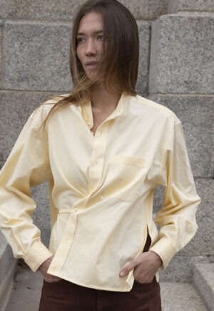 woman in pale yellow button-up wrap top and brown pants