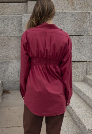 woman in red button-up and brown jeans