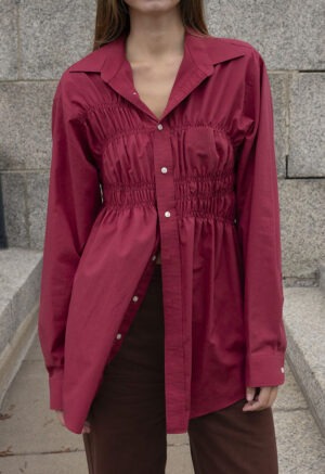 woman in red button-up and brown jeans