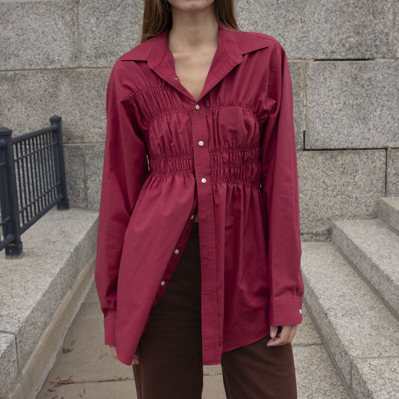 woman in red button-up and brown jeans