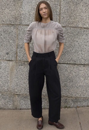 woman in shear ruched top and black trousers